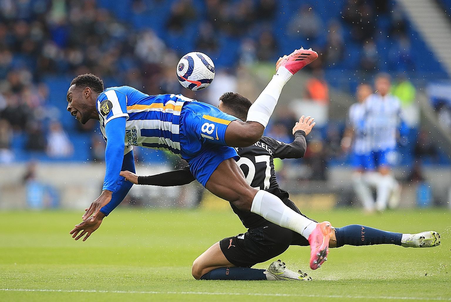 Left: Brighton striker Danny Welbeck getting involved in a clash with Manchester City's Joao Cancelo, who receives a red card (above) for his harsh tackle.