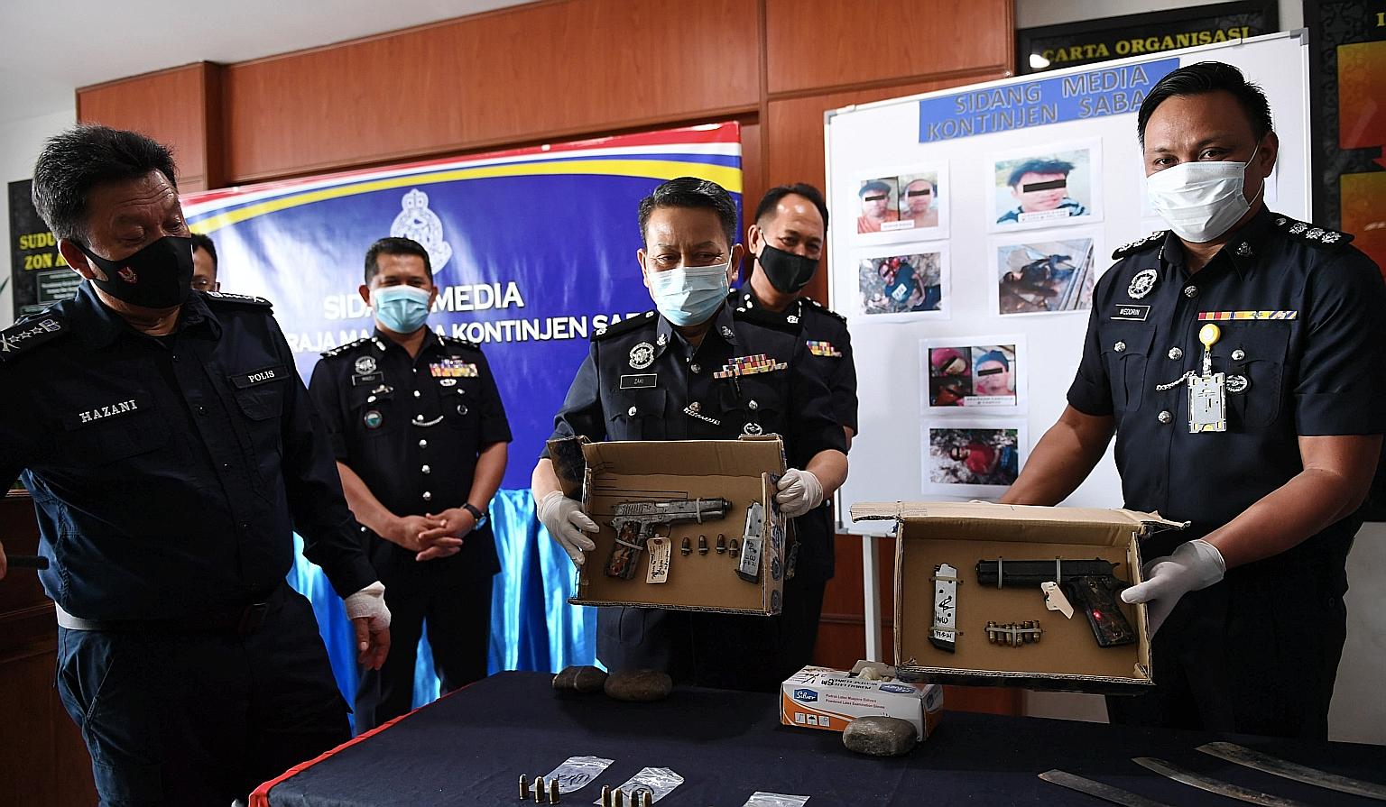 Sabah police chief Hazani Ghazali (centre) showing the guns used by the Abu Sayyaf members who were killed in the shootout with security forces on Monday.