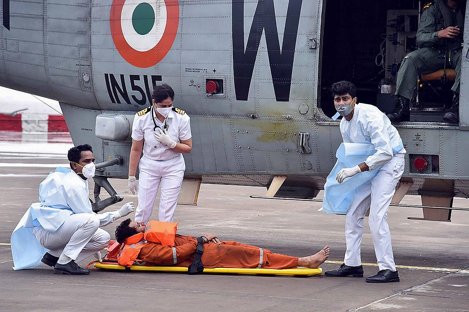 A photo from the Indian Navy showing its personnel helping an injured worker rescued from an offshore barge which had gone adrift amid heavy rain and strong winds caused by Cyclone Tauktae. The storm smashed into the Bombay High oilfield near Mumbai,
