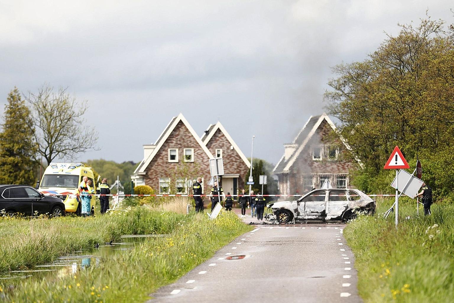 Emergency personnel near a burnt car in the Dutch village of Broek following a shootout between police and armed robbers on Wednesday. PHOTO: AGENCE FRANCE-PRESSE