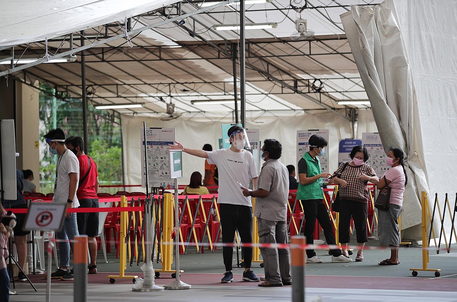 Staff at the vaccination centre at Kebun Baru Community Club were wearing face shields over their surgical masks yesterday. Food and beverage manager Sam Weng Kin, who was there for his jab, said this was a good move, noting that staff were not weari
