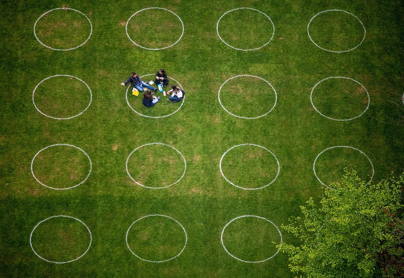 People inside a circle marked out for social distancing guidance in London's Canary Wharf district this week. Which vaccines a country can secure could affect everything from policy about mask-wearing and social distancing to lifting border restricti