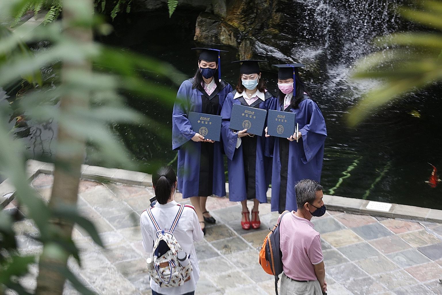 Graduates from the Singapore University of Social Sciences on their convocation day last month. The National University of Singapore and Nanyang Technological University said their decisions were based on uncertainty surrounding an ever-evolving Covi