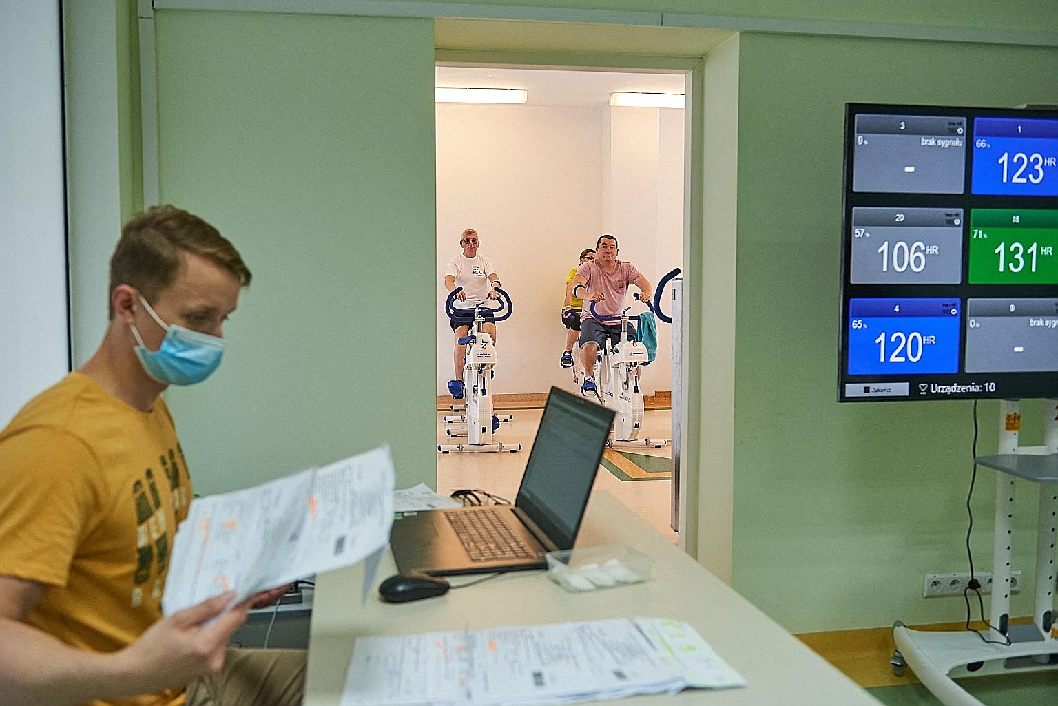 Recovered Covid-19 patients training on exercise machines at John Paul II Specialist Hospital in Krakow, Poland, during rehabilitation therapy for "long Covid" patients. Some people who have survived Covid-19 find that they continue to experience sym
