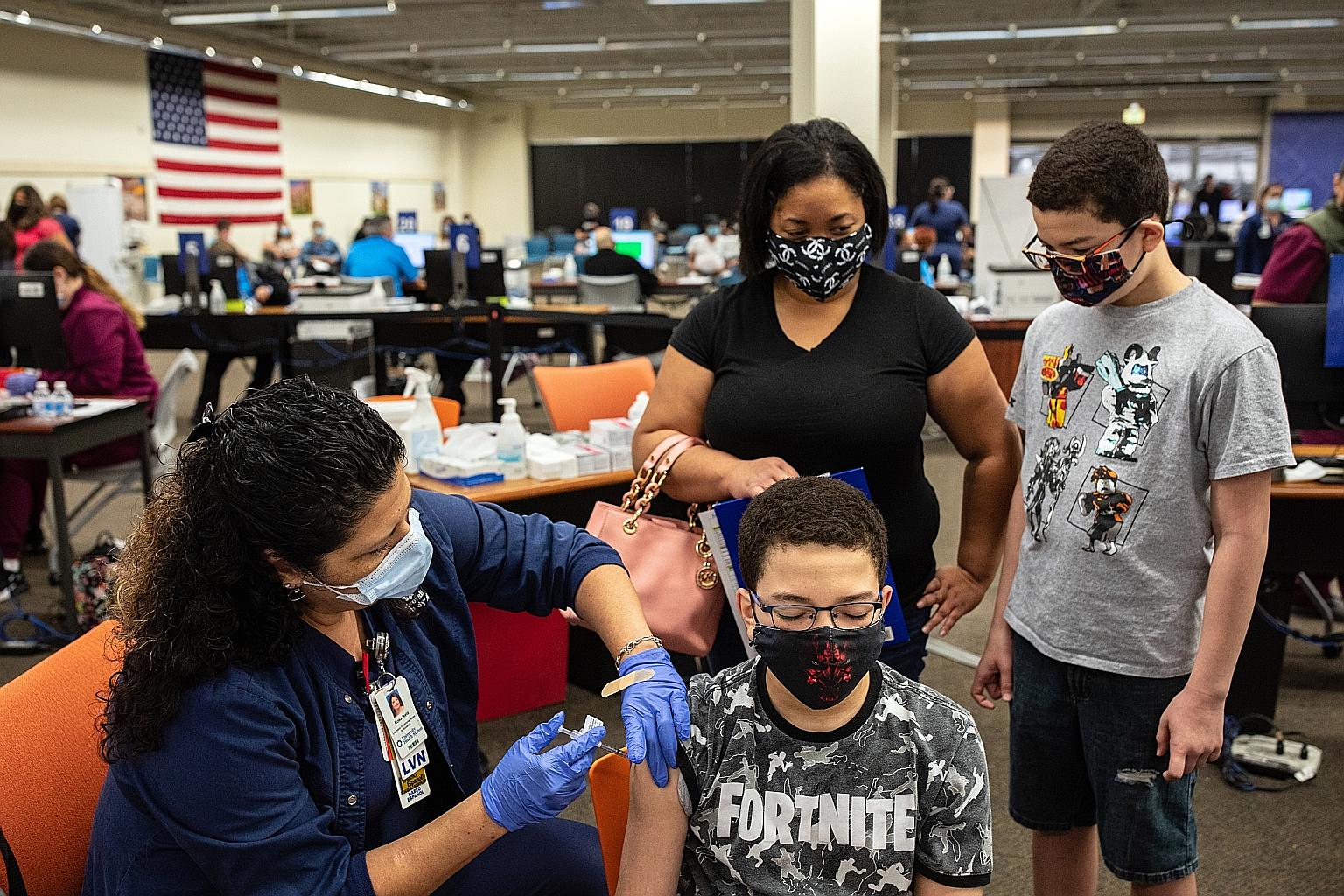 A 13-year-old boy getting a Pfizer-BioNTech jab at a mall in Texas on May 13. In Singapore, the Expert Committee on Covid-19 Vaccination said it had recommended the Pfizer vaccine for those aged 12 to 15 years following HSA's approval, and urged all 