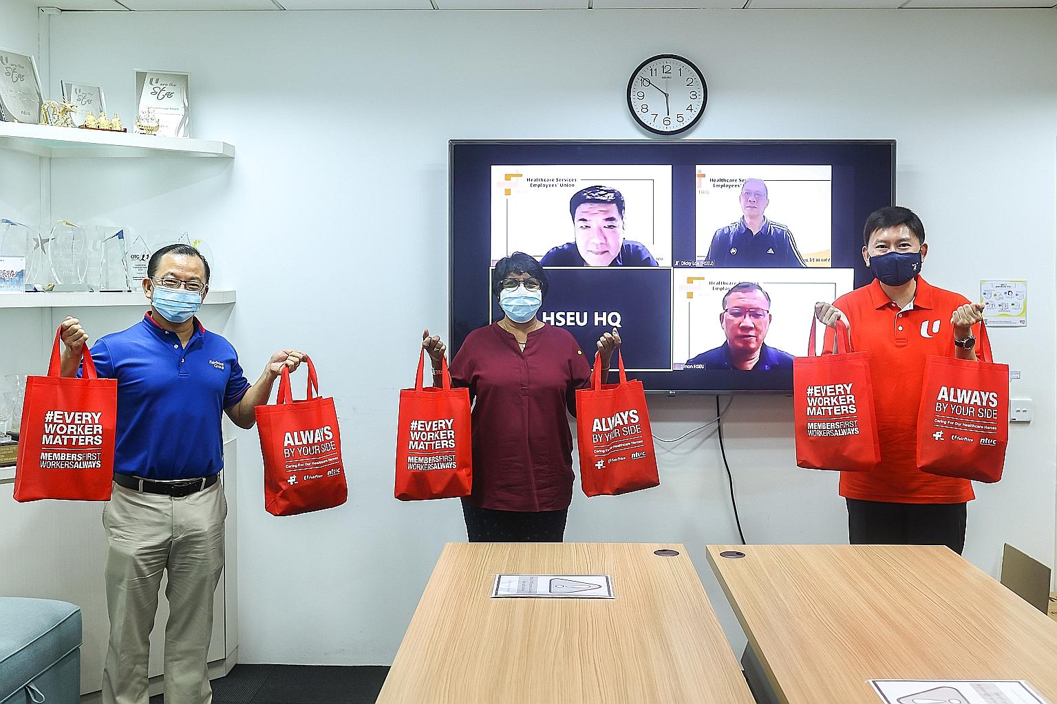 FairPrice group CEO Seah Kian Peng (left) and NTUC deputy secretary-general Chee Hong Tat (right) delivered the first batch of care packs for healthcare workers to Healthcare Services Employees' Union president K. Thanaletchimi at the union's headqua