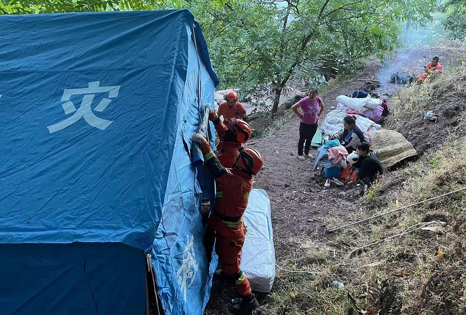 Firefighters setting up temporary tents for people displaced by an earthquake in Yangbi County, Dali Prefecture, in China's south-west Yunnan province yesterday. PHOTO: AGENCE FRANCE-PRESSE