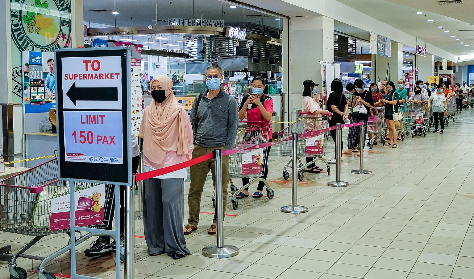 People lining up to buy essentials at a supermarket on Friday. There were long queues at stores ahead of the government announcement on stricter movement curbs yesterday.