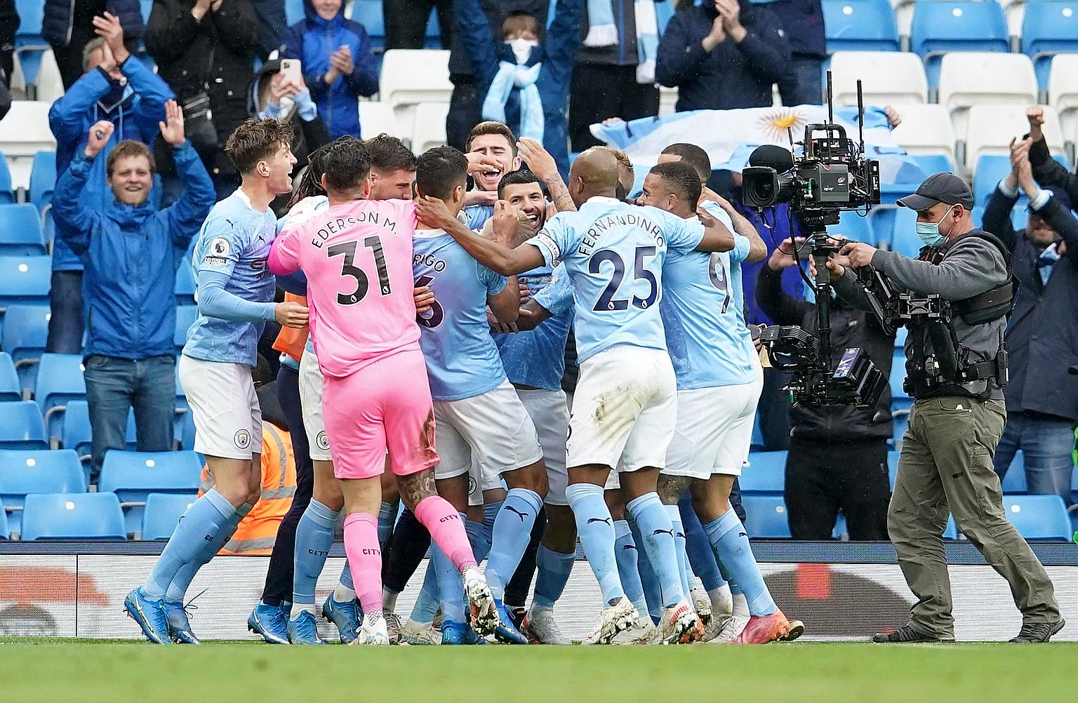 Sergio Aguero is mobbed by his Manchester City teammates after scoring the fourth goal in their 5-0 thrashing of Everton yesterday.