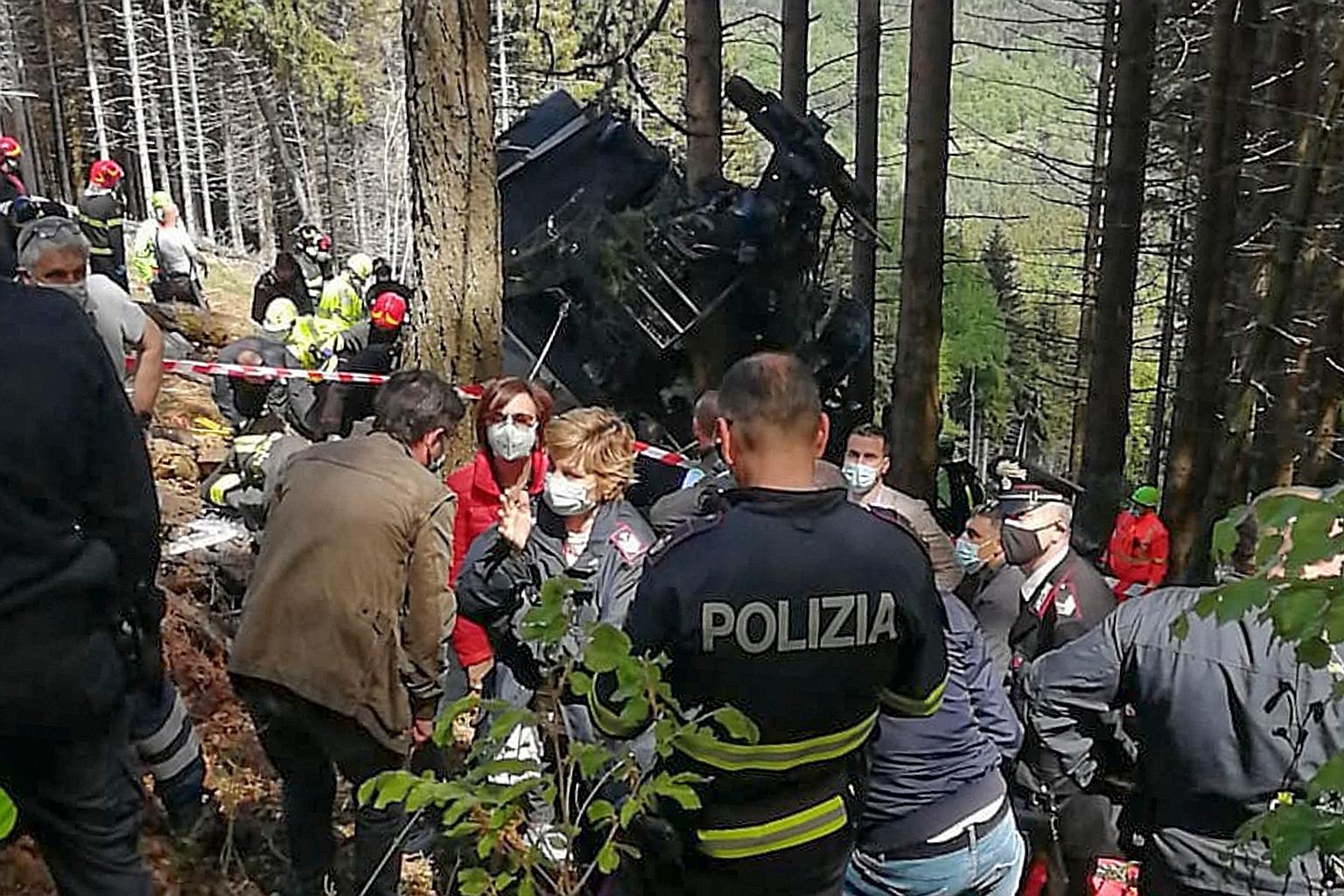 A photo taken by Italian news agency Ansa yesterday showing the white and red cabin that crashed in a steep wooded area where access appeared difficult. A handout photo taken by the Italian state police Polizia di Stato yesterday showing police offic