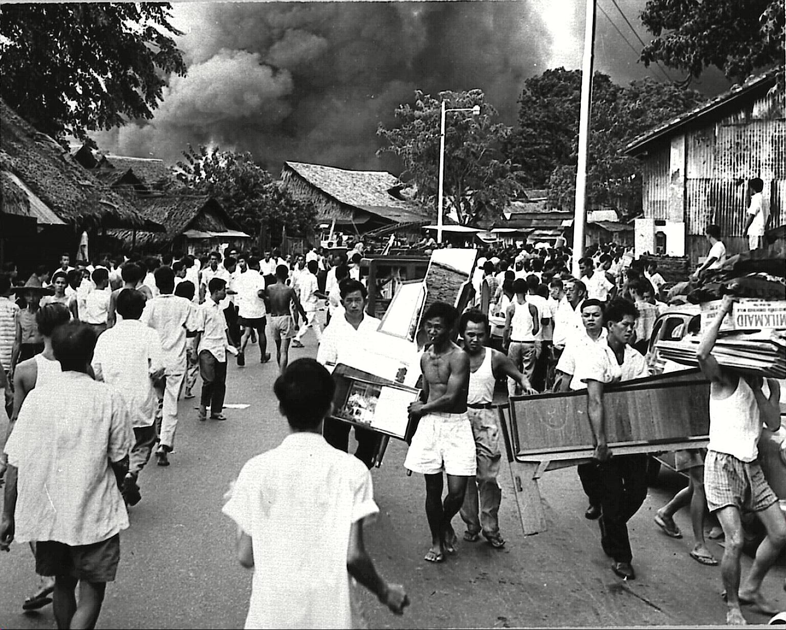 Former residents surveying the ruins of their homes in the aftermath of the fire. Within nine months of the blaze, all the victims were rehoused in flats. The opening in September 1961 of five HDB blocks with 904 one-room, semi-communal units, all of