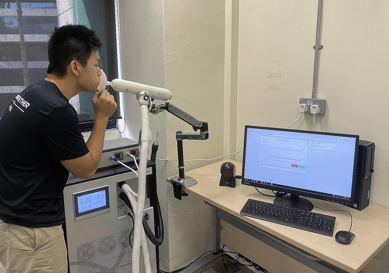 Mr Chan Tiong Ley, head of software and partnerships at Breathonix, demonstrating how the non-invasive breath test system is used. A person being tested for Covid-19 simply breathes out into a disposable mouthpiece connected to a breath sampler.