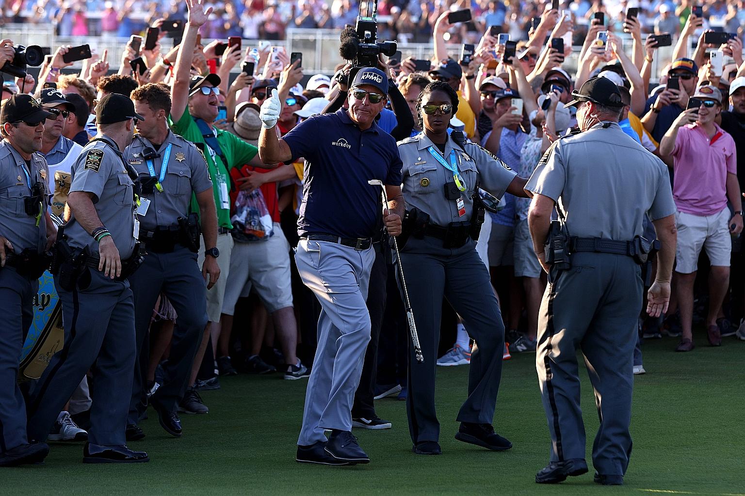Security guards holding back the enthusiastic crowd on the 18th green at Kiawah Island as Phil Mickelson prepares to win the PGA Championship for his sixth Major title.