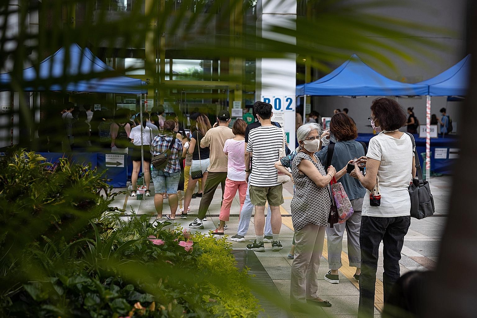 People lining up outside a community vaccination centre in Hong Kong to receive the Covid-19 vaccine. Residents are offered free jabs as part of a massive vaccination drive but public distrust of the government and fears about the safety of vaccines 