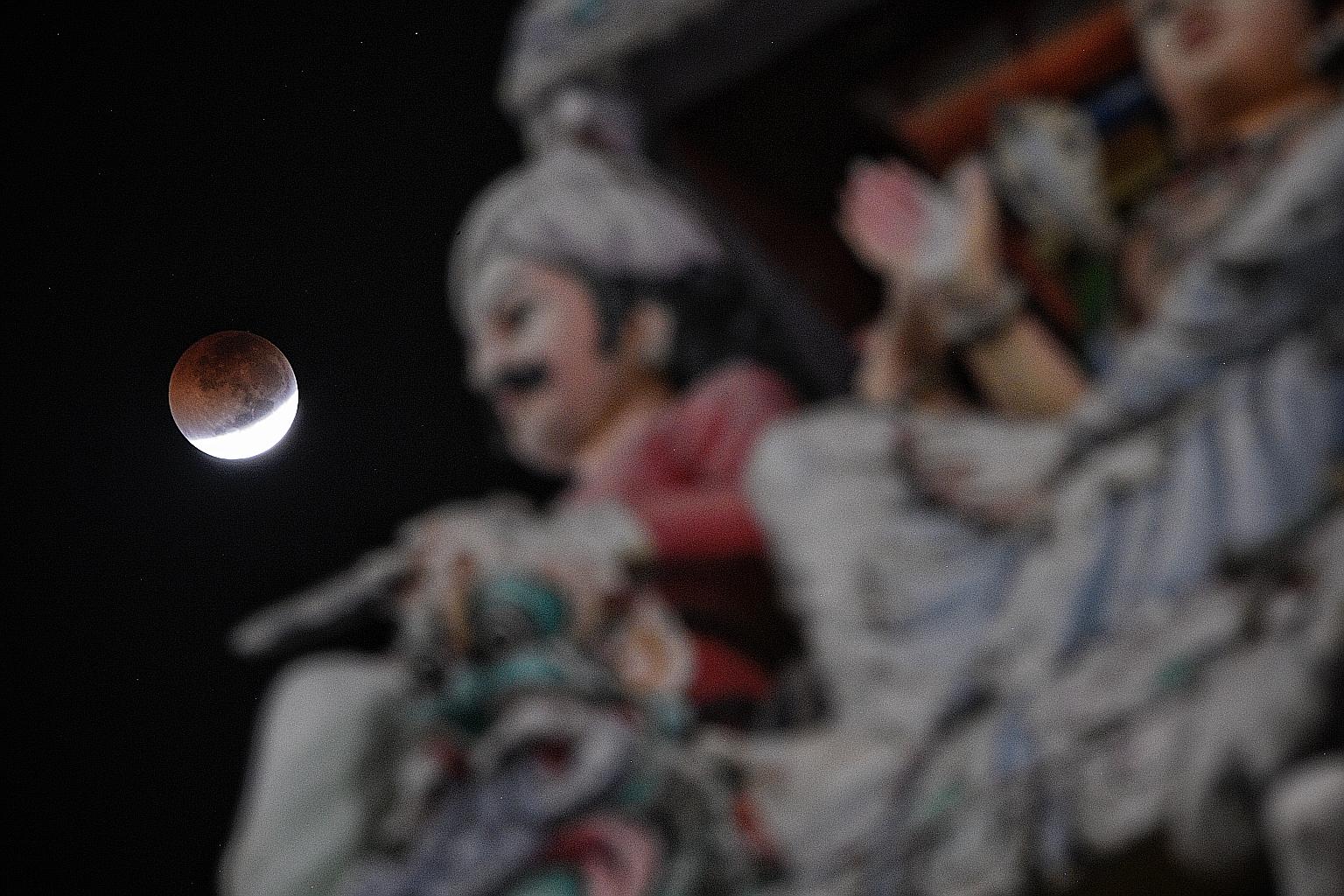 A view of the Moon, seen near Sri Mariamman Temple in South Bridge Road minutes before a total lunar eclipse on July 28, 2018. To catch a glimpse of the cosmic spectacle this evening, stargazers will need a good view of the eastern horizon without an