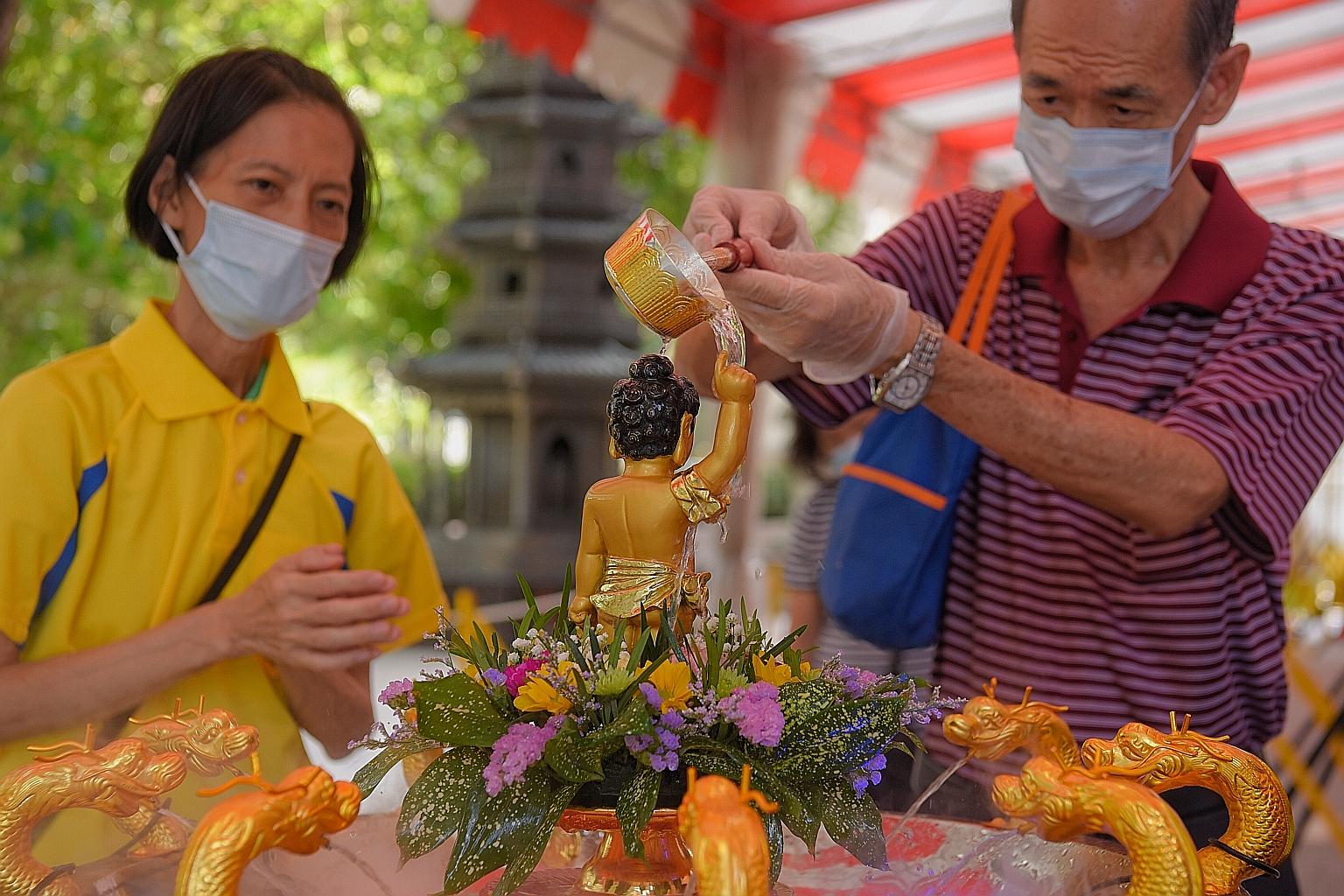 At the Singapore Buddhist Lodge today, devotees marking Vesak Day will be required to wear disposable gloves when performing the symbolic ritual of bathing a Buddha statue. ST PHOTO: MARK CHEONG