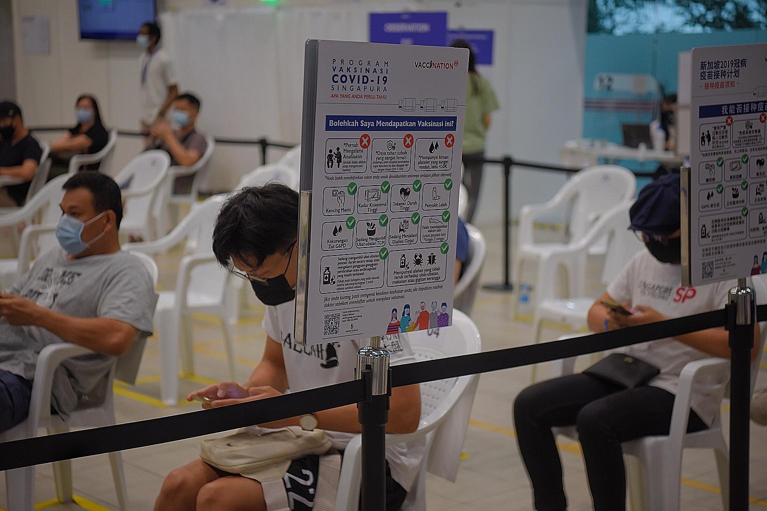 People waiting in the observation area at the Covid-19 vaccination centre at Yew Tee Community Club last week, after receiving their jabs. Slightly more than one-third of the population in Singapore have been given at least one dose of a Covid-19 vac
