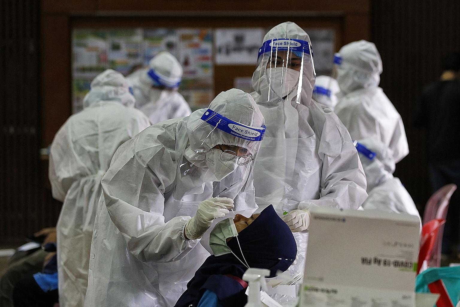 A woman getting a swab test for Covid-19 in Kuala Lumpur last week. Yesterday marked the second day in a row that Malaysia's new Covid-19 cases have surged above 7,000.