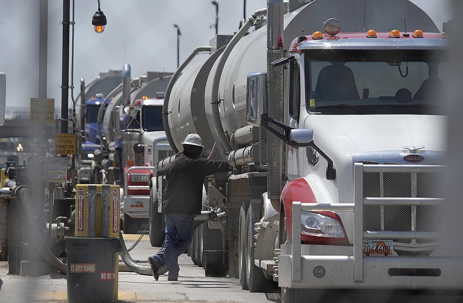 A US driver emptying his tanker truck of crude oil in Utah last week. Oil was steady yesterday, buoyed by optimism about improving US fuel demand and a weak dollar. However, reports also showed that US new home sales slid and consumer confidence fell
