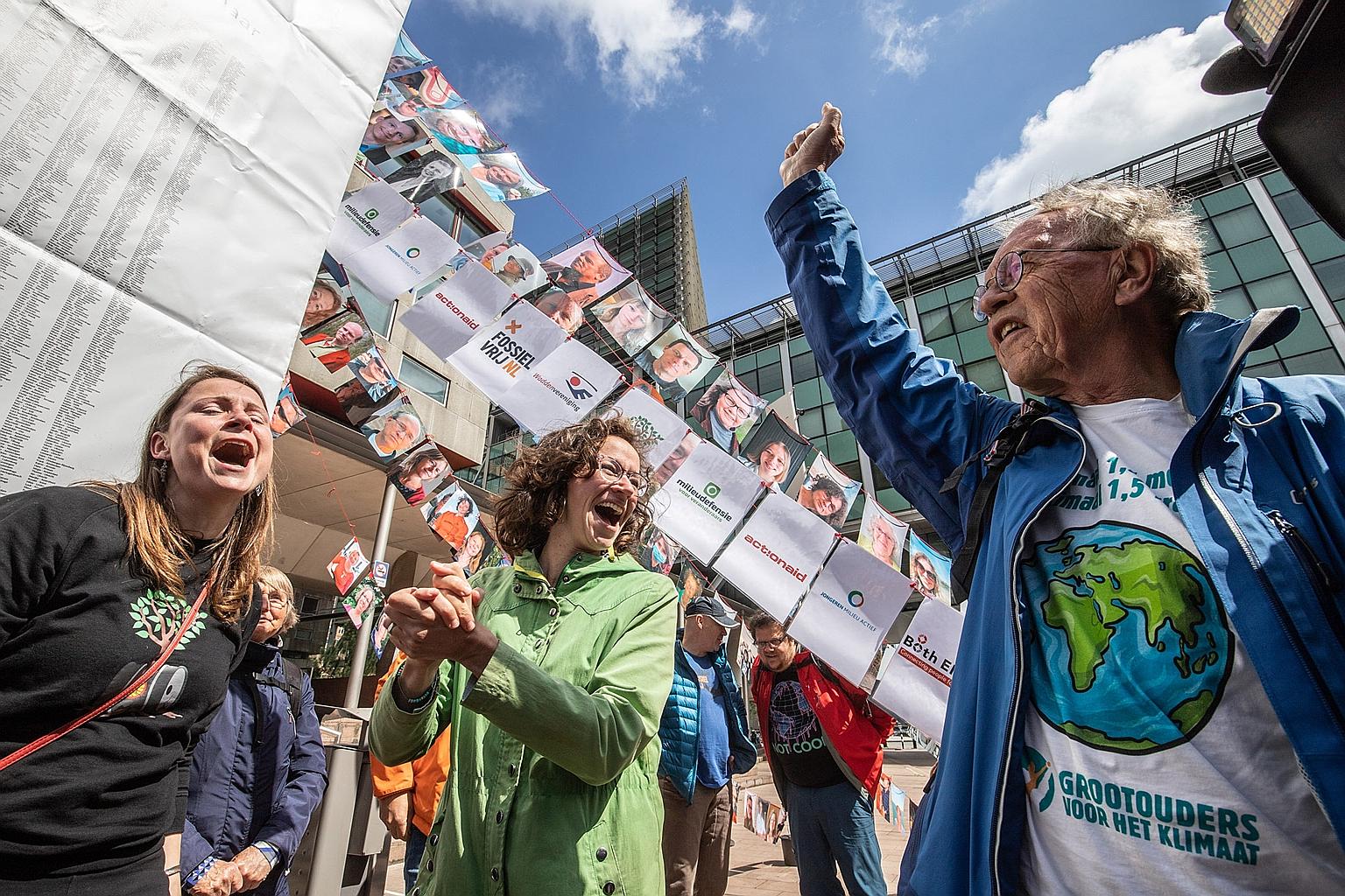 Members of Dutch environmental group MilieuDefensie celebrating the verdict of the case against Royal Dutch Shell outside the Palace of Justice courthouse in The Hague in the Netherlands, yesterday. The oil giant was dealt a blow as it was ordered to
