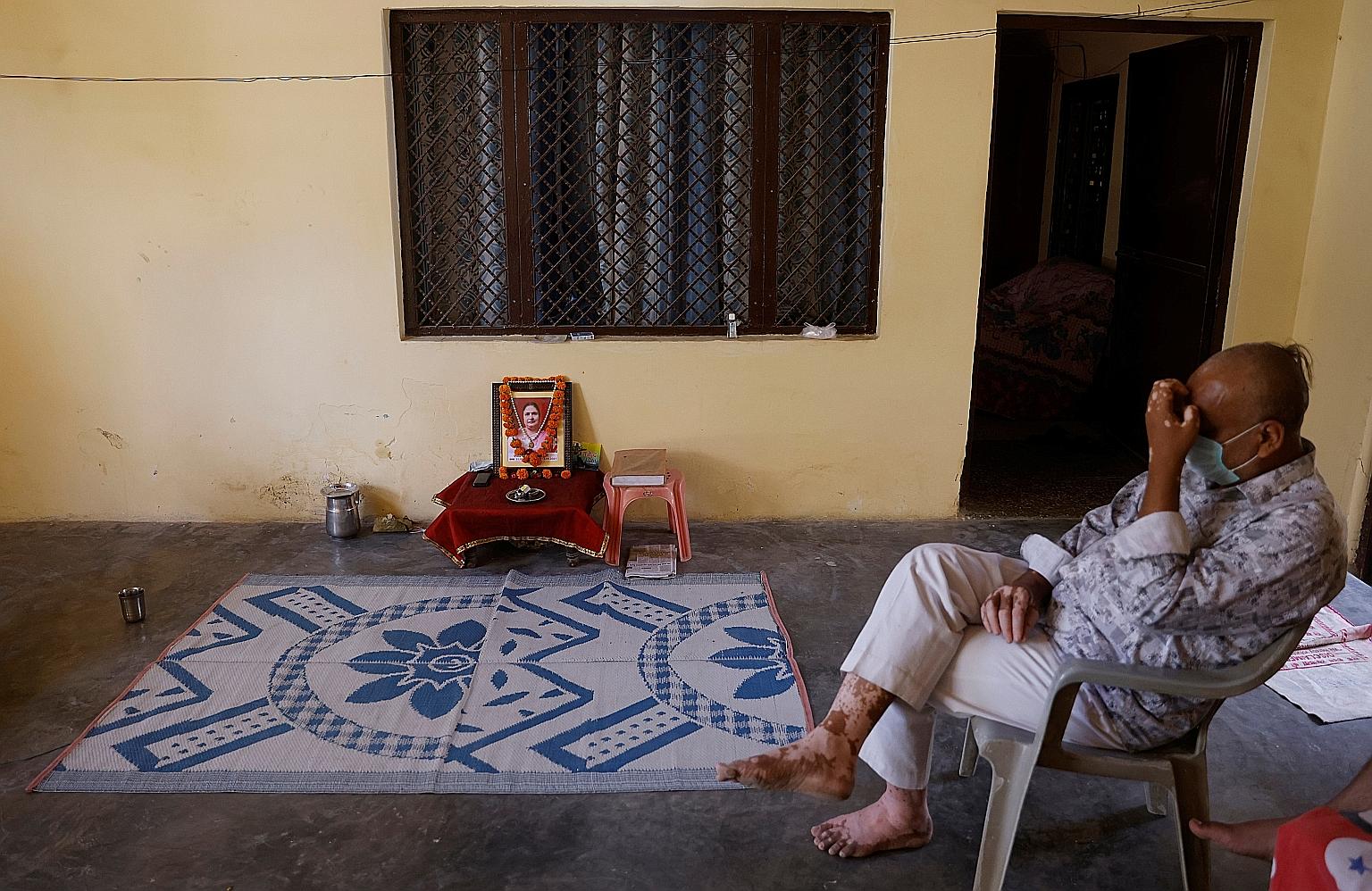 Mr Akhilesh Agarwal, 49, whose wife Suman Lata died of Covid-19 after she performed her local election duty last month, sitting next to a picture of her at their house in Uttar Pradesh, India, on Tuesday.