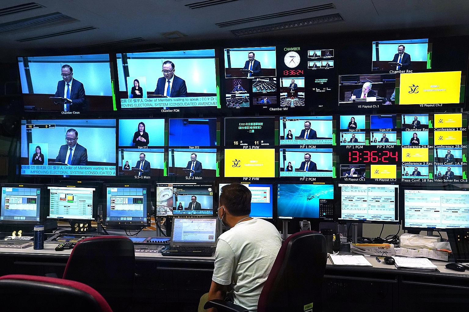 Live footage of the debate on the electoral reform Bill shown yesterday in a control room at the Legislative Council in Hong Kong. The council voted 40-2 to approve measures creating a review committee to vet candidates for elected office, dramatical