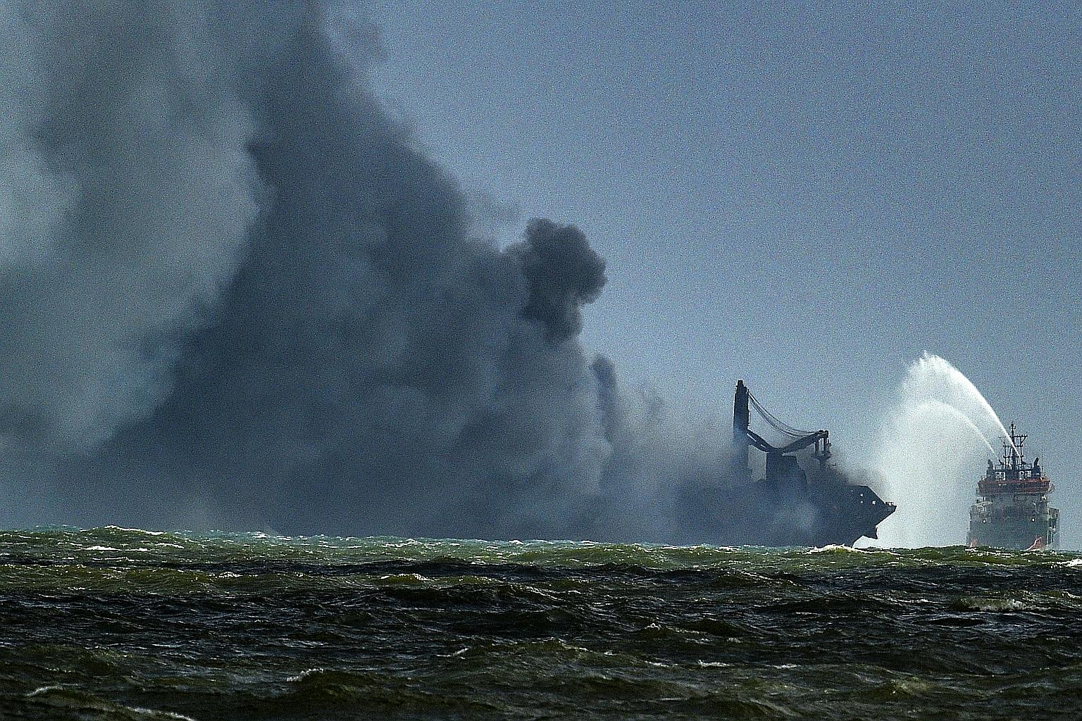 A Sri Lankan navy ship attempting to douse the fire on the Singapore-registered container ship X-Press Pearl yesterday, in the sea off the coast of Colombo. All 25 foreign crew members were safely evacuated on Tuesday. Two seafarers remain in stable