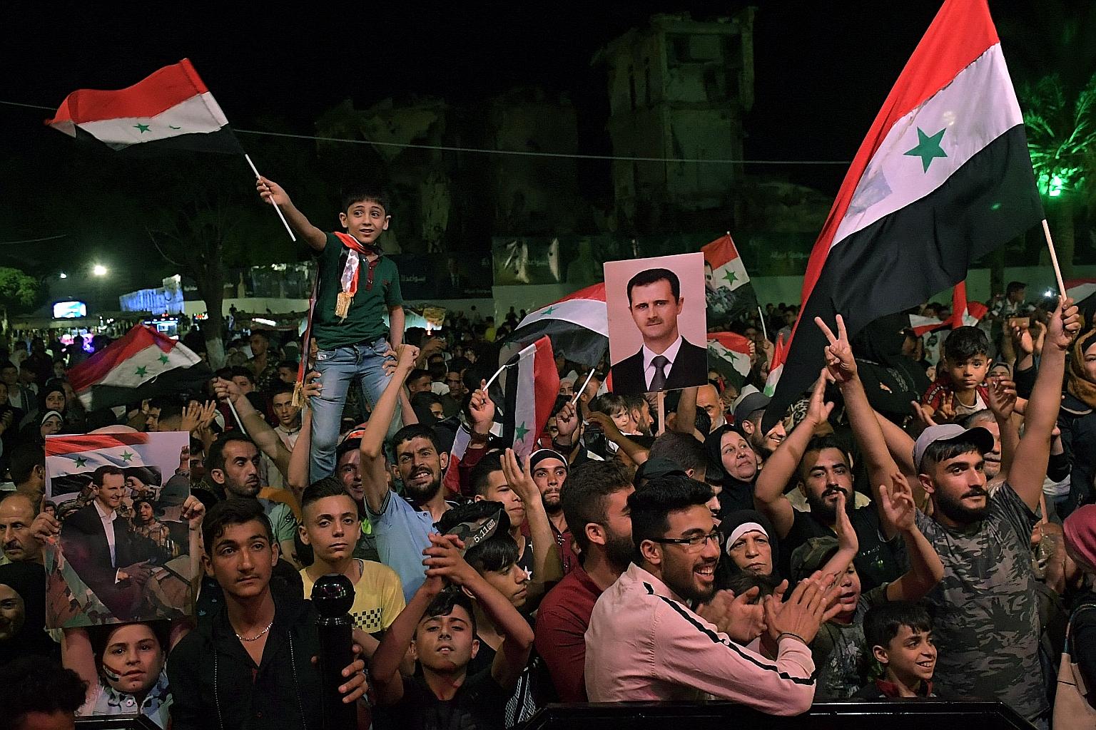 People celebrating in the streets of Aleppo on Thursday as Mr Bashar al-Assad was re-elected for a fourth term as president of war-ravaged Syria. The election - which opponents and the West say was marked by fraud - went ahead despite a United Nation