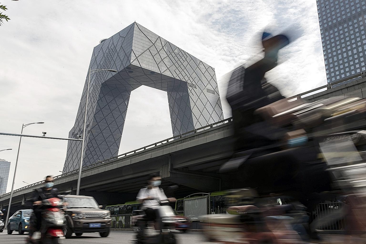 Motorists driving past the headquarters of China Central Television in Beijing. With China's economy rebounding from the Covid-19 pandemic and foreign funds piling into its equity and bond markets, the renminbi surged past crucial levels that have he