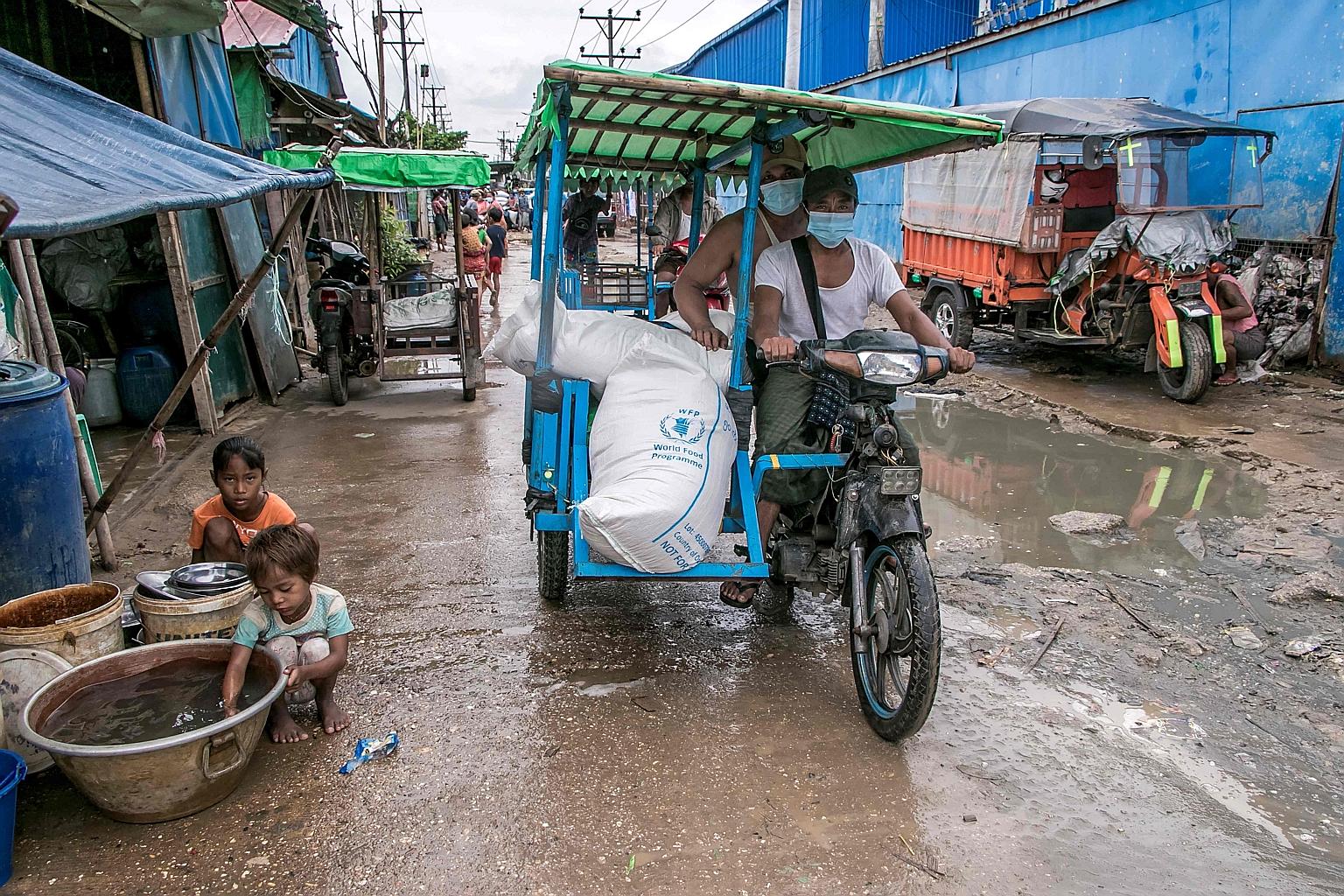 Bags of rice distributed by the World Food Programme being transported as part of food aid efforts to support residents living in poor communities on the outskirts of Yangon. The programme estimates that within the next six months, as many as 3.4 mil