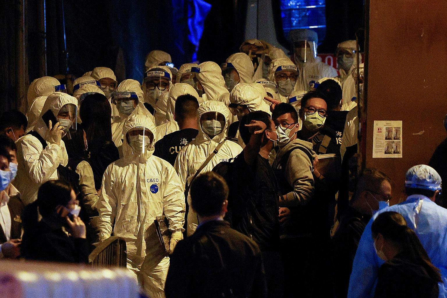 Workers in protective suits arriving at the locked-down part of the Sai Ying Pun area in March. Since Jan 23, the government has carried out 47 such "ambush lockdowns" islandwide, involving 200 buildings and 40,000 residents. In all, 22 Covid-19 case