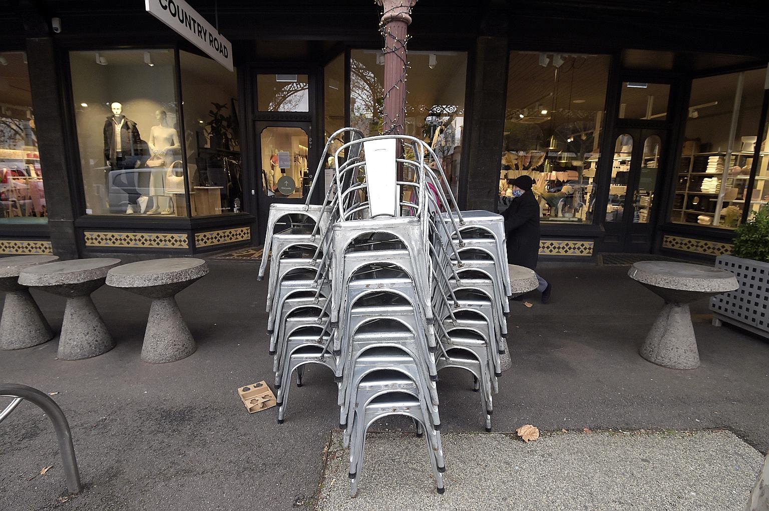 Above: Stacked chairs outside a cafe during a lockdown in Melbourne in the state of Victoria last Friday, following an outbreak. Left: