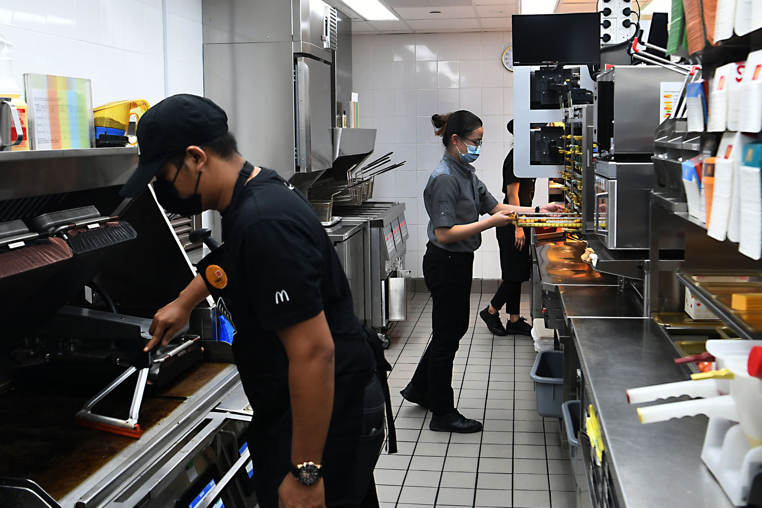 Food for delivery and takeaway at the Pizza Hut outlet at Compass One is left on tables to be picked up. Kitchen staff at the McDonald's outlet at Canberra Plaza follow a "stay in position" work system, with each person remaining in his spot, keeping