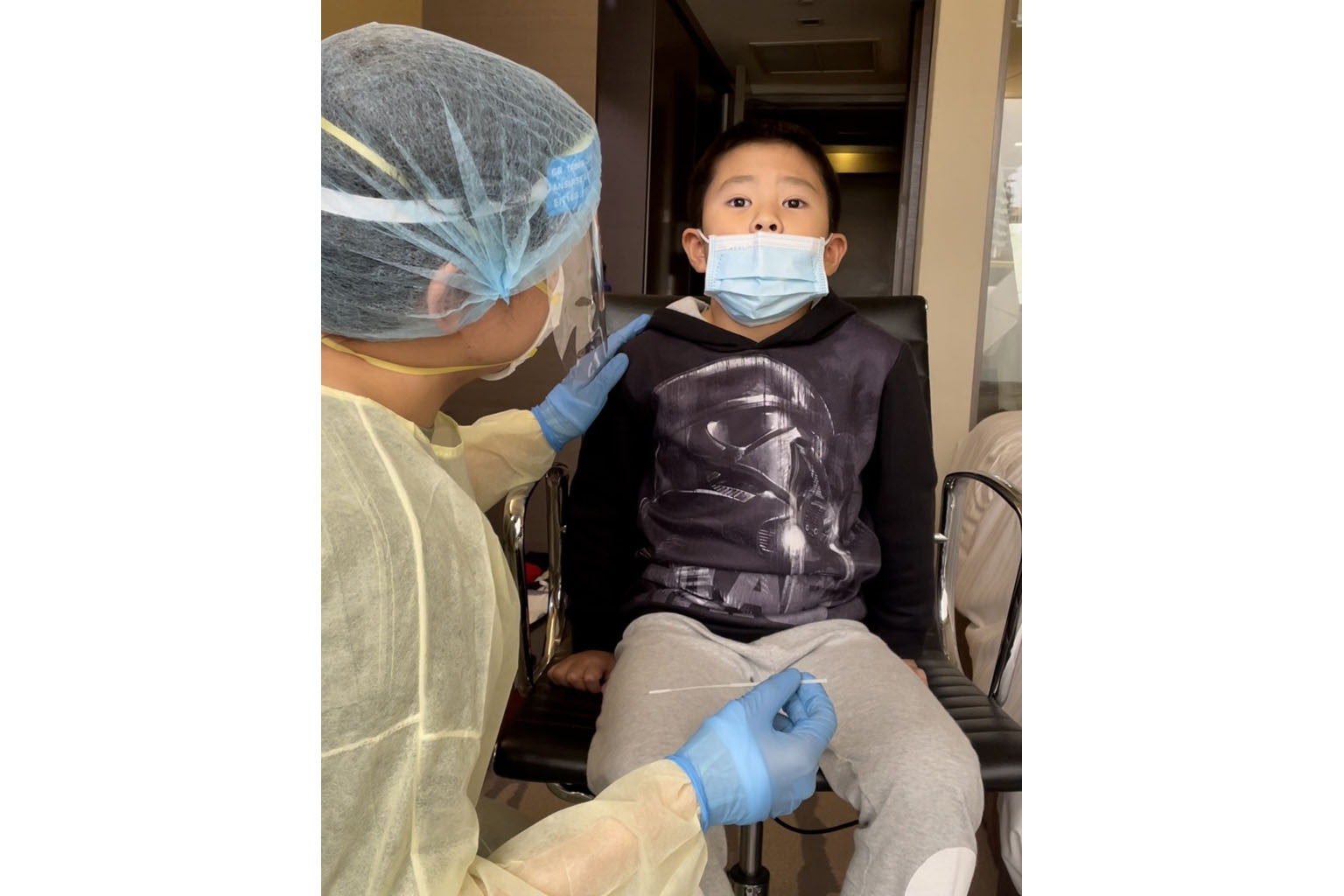 THE SWABBERS Medical officer Raymus explaining the swabbing process to Isaac Lee, eight, in his hotel room at Grand Park Orchard where he was serving a quarantine order. ST PHOTO: RHODA CHUA
