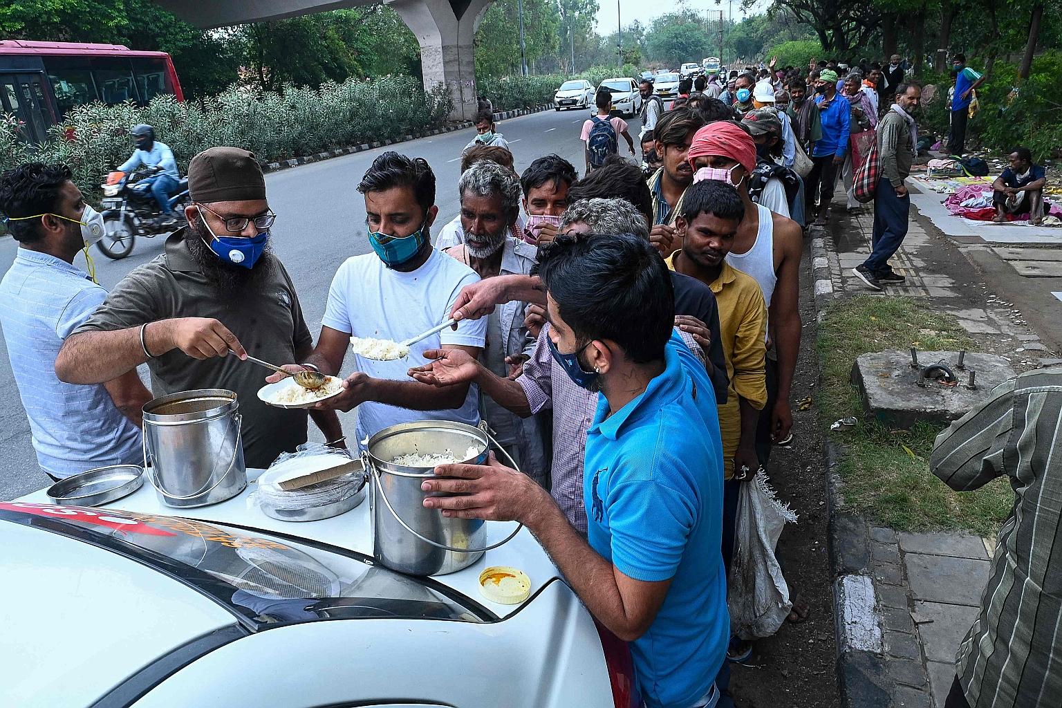 Homeless people, mostly working as daily-wage labourers after losing their jobs during the pandemic, queueing to get food from volunteers at a roadside in New Delhi recently. During last year's Covid-19 lockdown, about 100 million people in India los