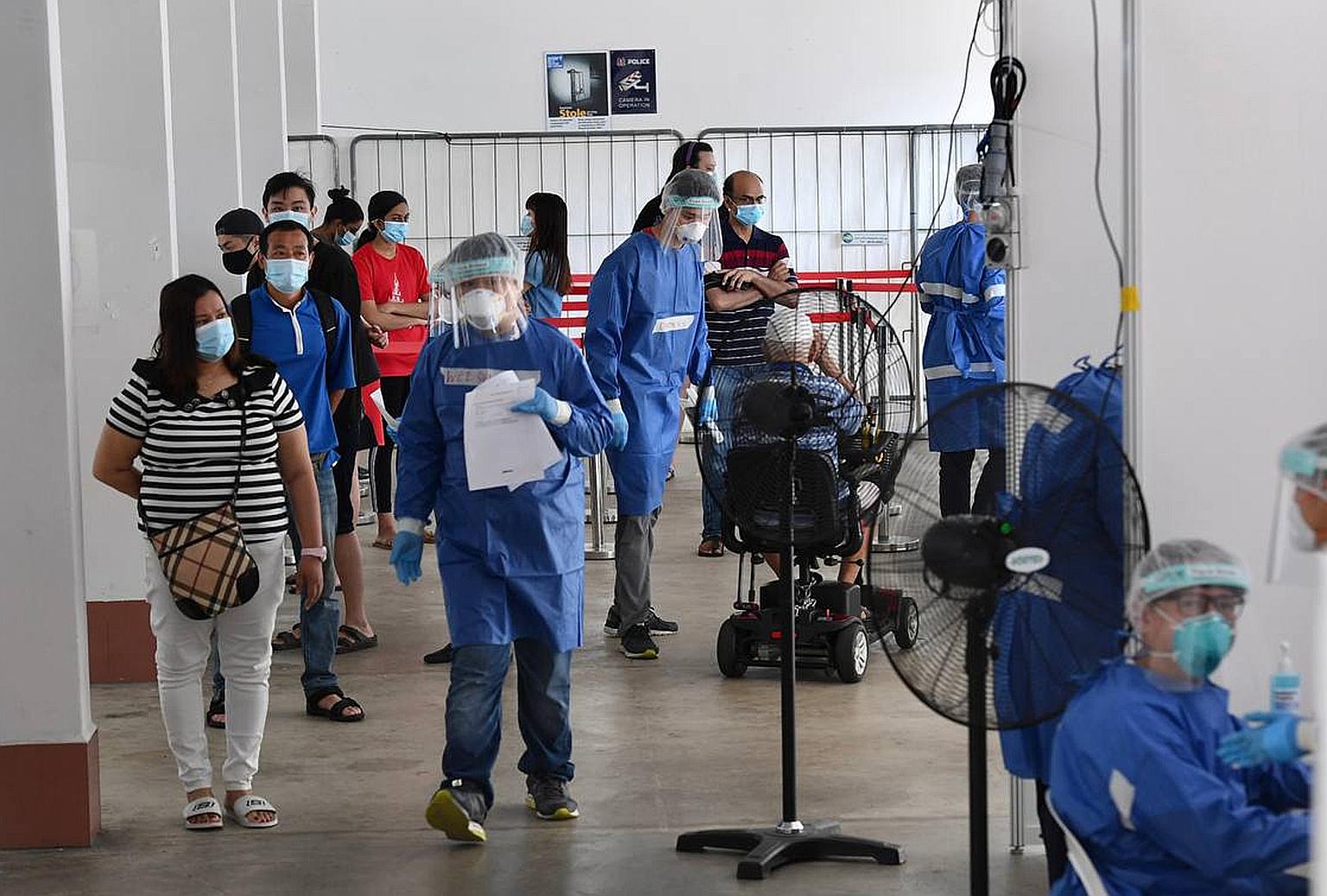 Residents of Block 745 Yishun Street 72 waiting to be tested for Covid-19 yesterday. Surveillance testing had detected six cases among the block's residents. ST PHOTO: DESMOND FOO