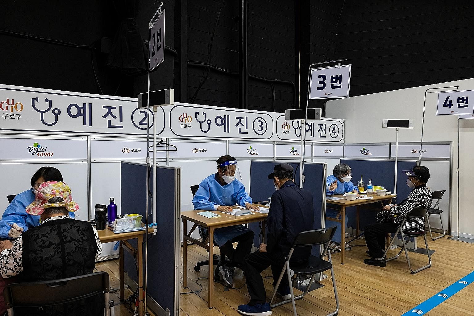 Elderly residents speaking with doctors before receiving a dose of the Pfizer-BioNTech Covid-19 vaccine at a vaccination site at Guro Arts Valley Theatre in Seoul's Guro district. Only 4.5 per cent of South Korea's population, or 2.32 million people,