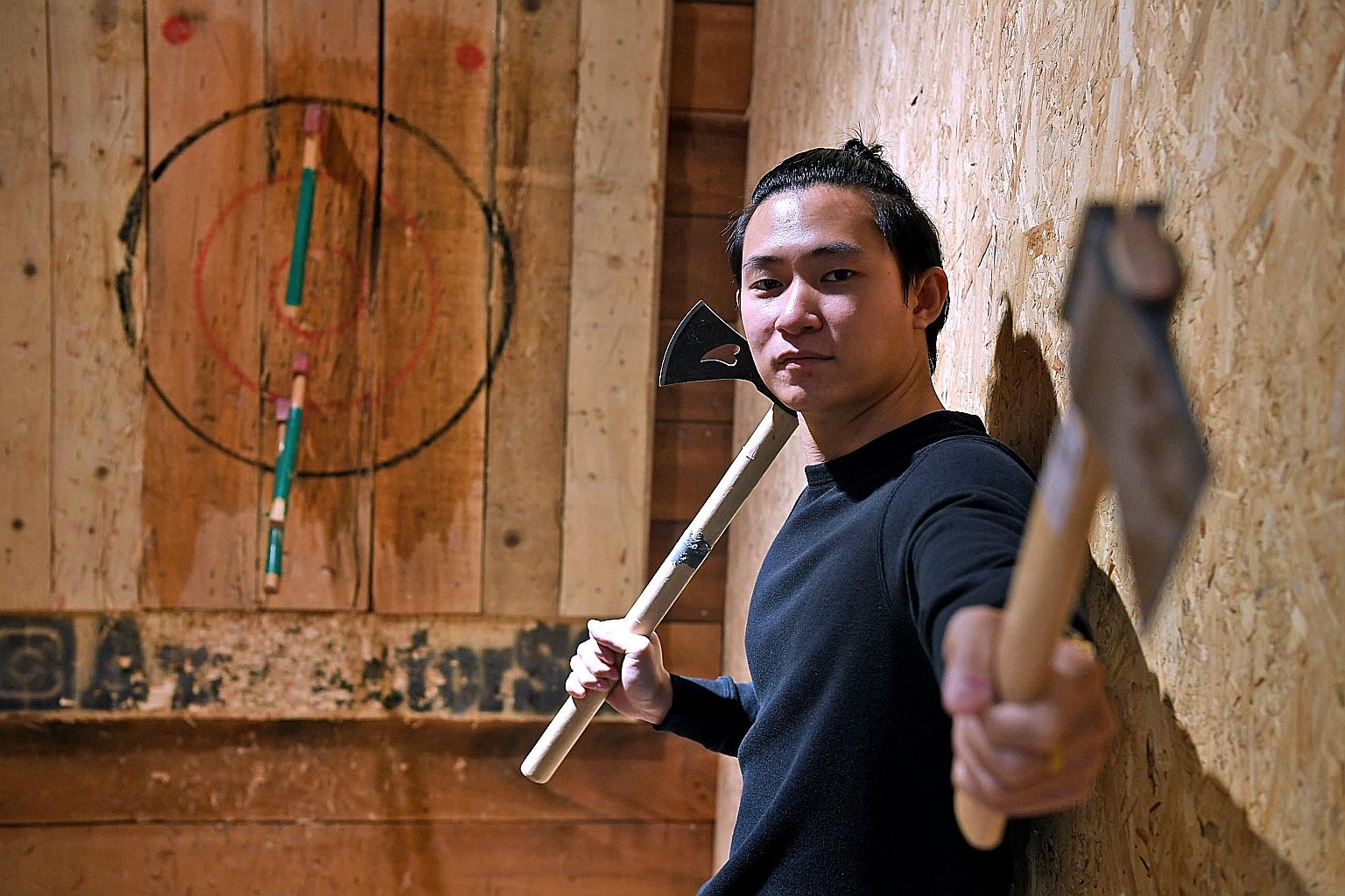 Axe Factor founder Samuel Tey with the tools of the sport, which involves participants hurling axes at a target board some 4m away. ST PHOTO: DESMOND FOO