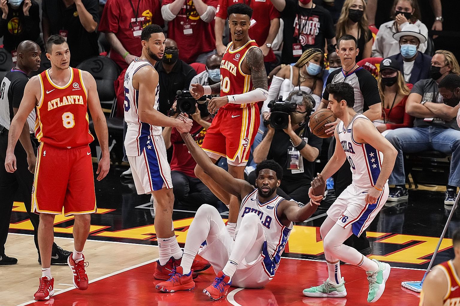Despite playing with an injured knee, Philadelphia 76ers centre Joel Embiid (on the ground) scored 27 points, in his side's 127-111 win over the Atlanta Hawks in Game 3 of their semi-final series. PHOTO: REUTERS