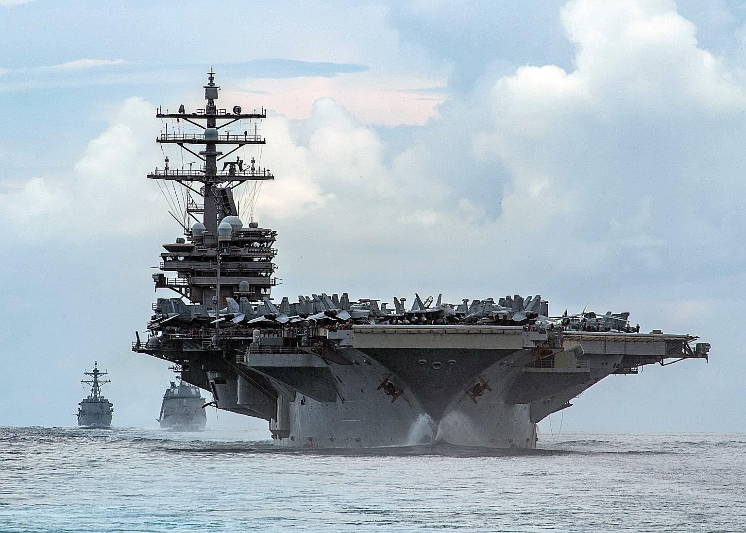 The fly-by of 28 Chinese air force aircraft into Taiwan air space on Tuesday happened on the same day the US Navy said a carrier group led by the USS Ronald Reagan (above) entered the South China Sea. China, which claims almost all of the disputed wa