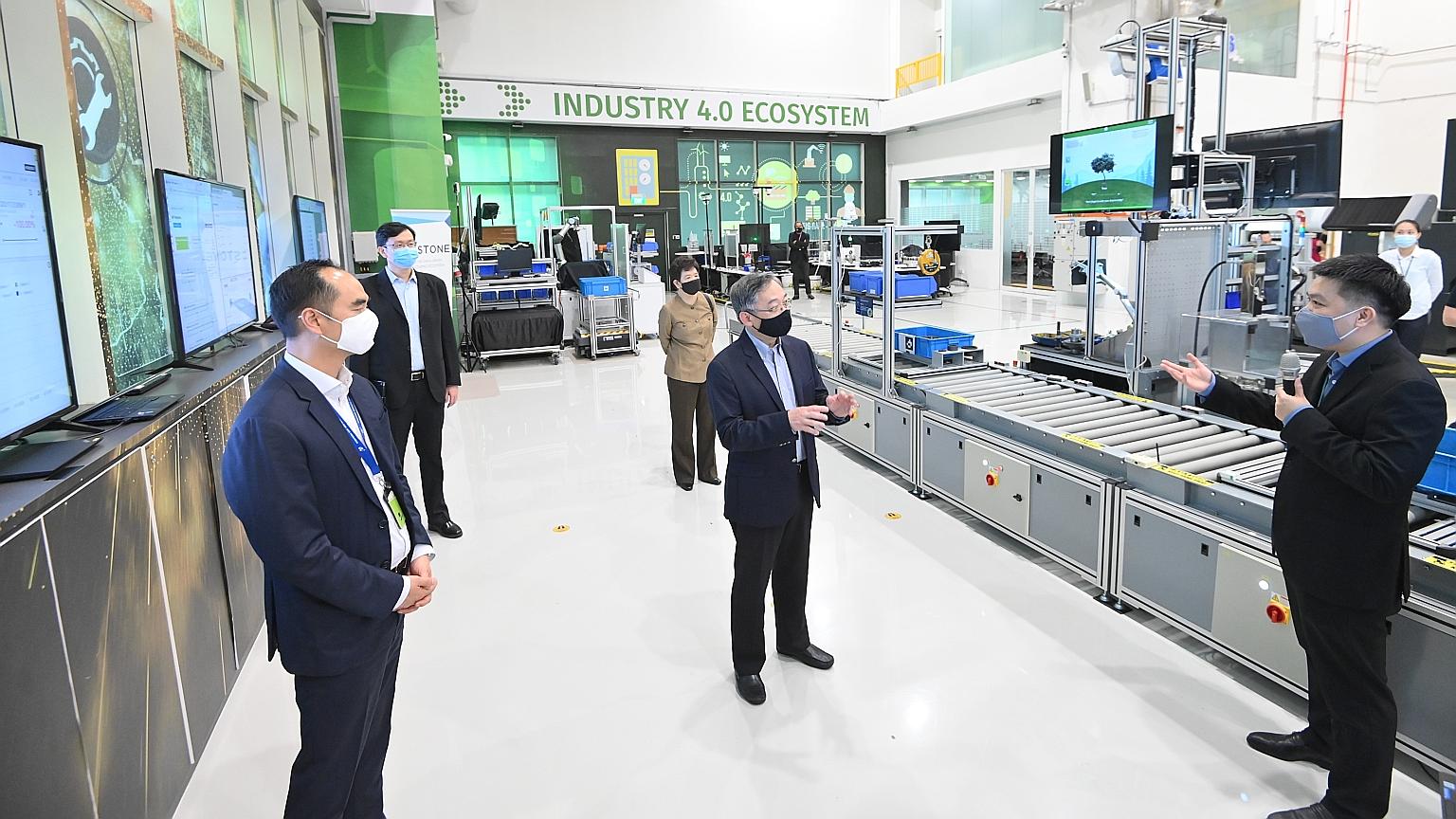 Minister for Trade and Industry Gan Kim Yong (centre) visiting the new facility set up jointly by A*Star and local manufacturing software company Arcstone yesterday. Sharing the lab details is Mr Willson Deng, chief executive of Arcstone. At the lab'