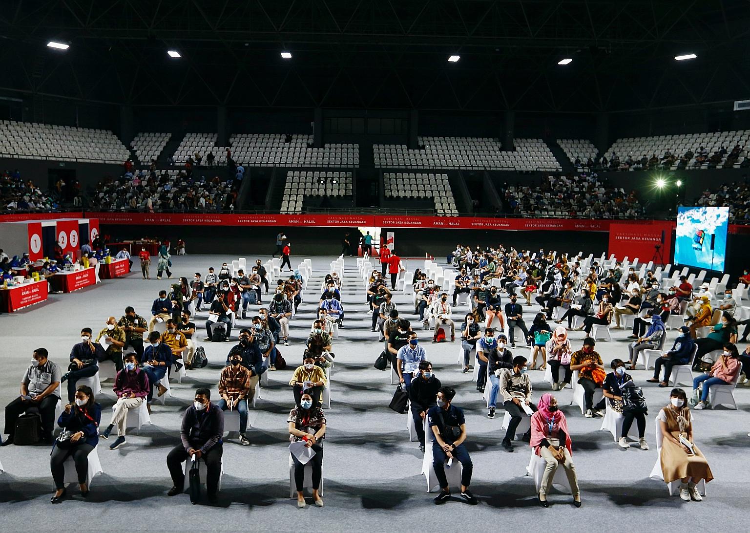 People waiting to get the AstraZeneca jab at a Jakarta stadium on Wednesday. Almost all healthcare staff in Indonesia have received the Sinovac vaccine. While the number of Covid-19 deaths among them has fallen, experts say the cases of medical staff
