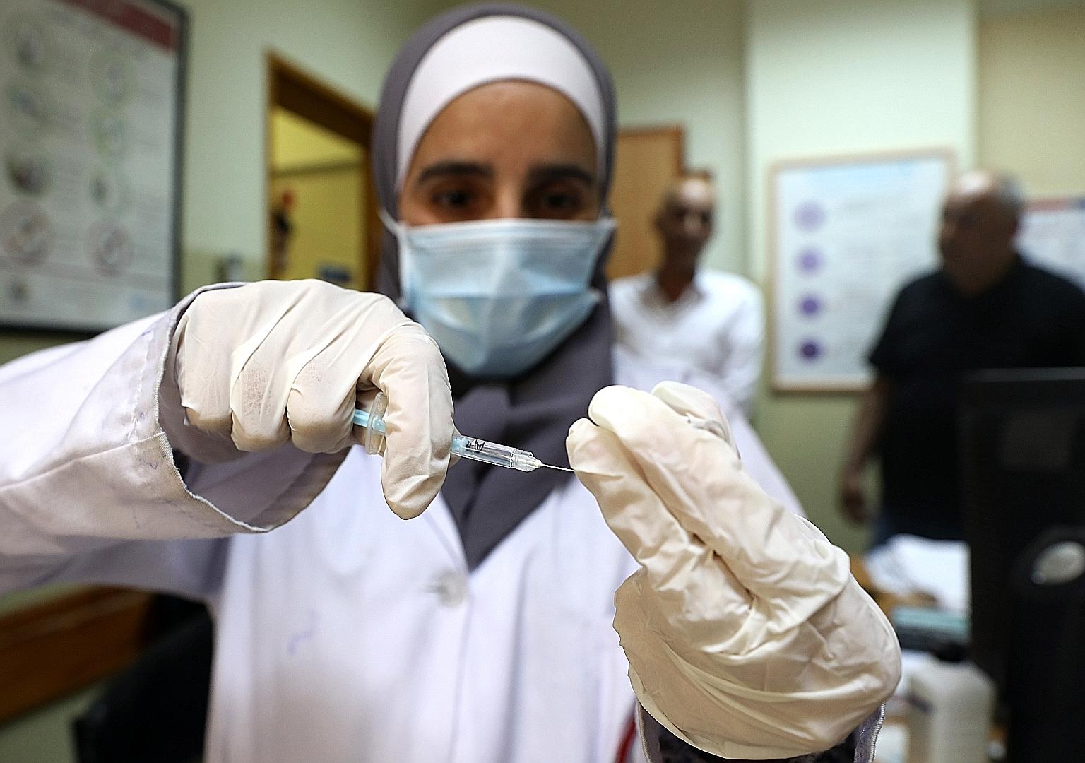 A Palestinian medical worker preparing a dose of the Pfizer-BioNTech vaccine at a healthcare centre in the West Bank city of Dura this month.