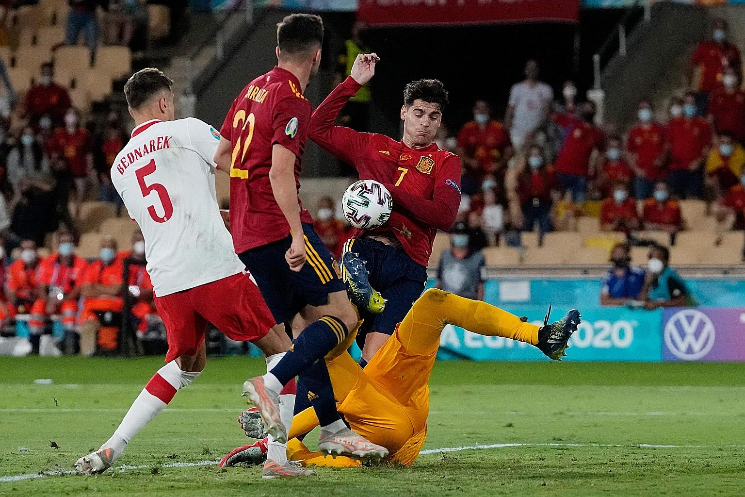 Spain striker Alvaro Morata (right) challenging Poland goalkeeper Wojciech Szczesny for the ball during the 1-1 Group E draw on Saturday. The Spaniards need to beat Slovakia to ensure qualification for the last 16.