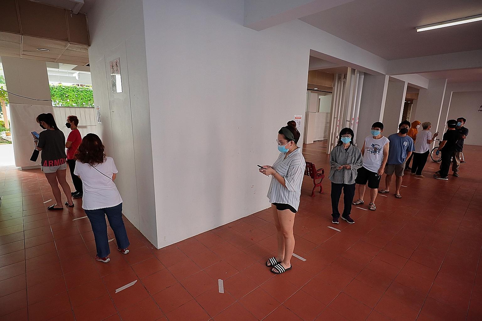 People queueing up yesterday at the Covid-19 testing site at Block 118 Bukit Merah View, one of three designated testing sites set up in the neighbourhood for residents of eight Housing Board blocks in the area, as well as for those who had visited t
