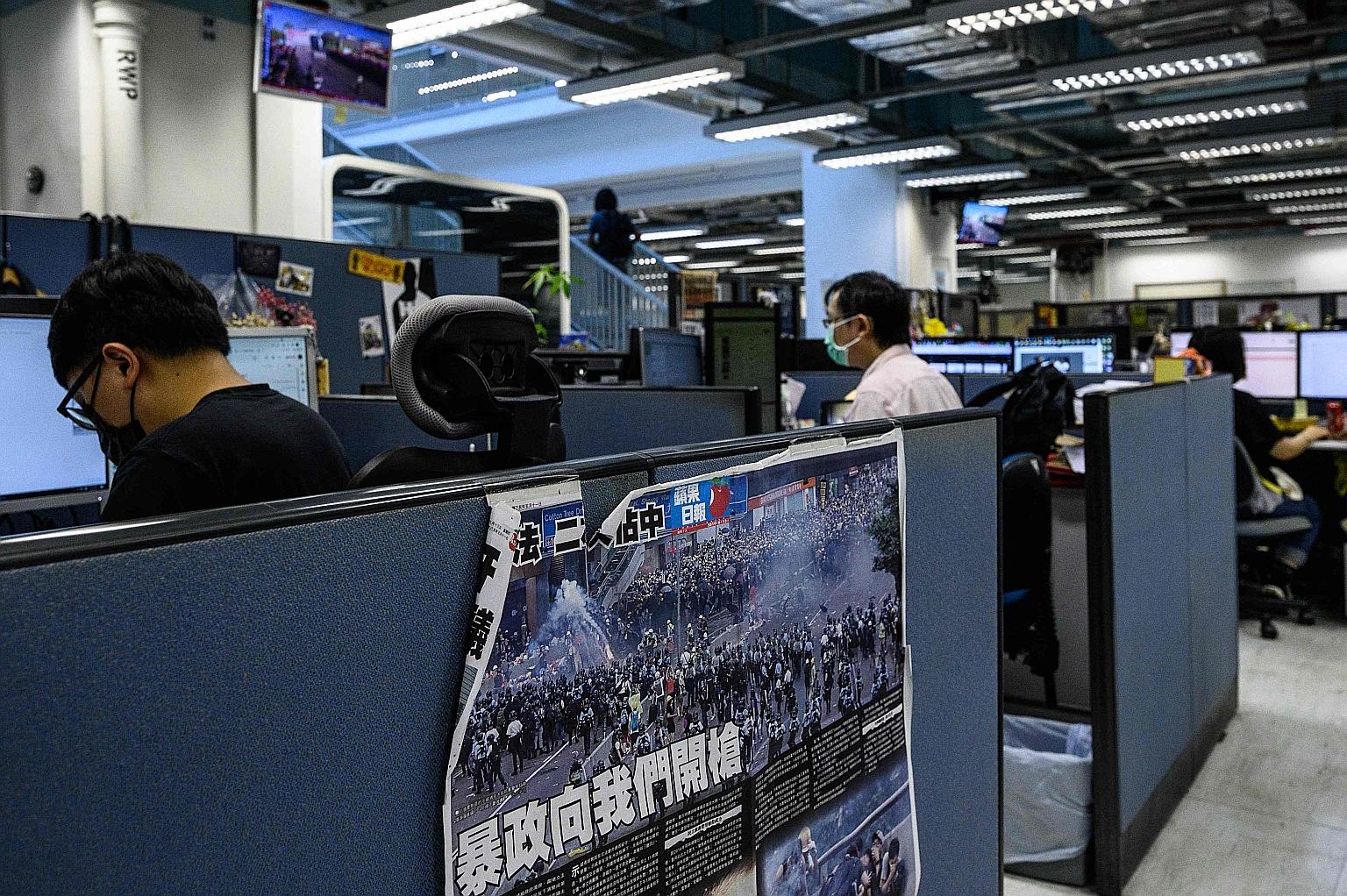 Apple Daily staff at the tabloid's office in Hong Kong last Thursday. Police raided the newspaper last week in a national security probe, in which senior executives were arrested for "collusion with a foreign country".