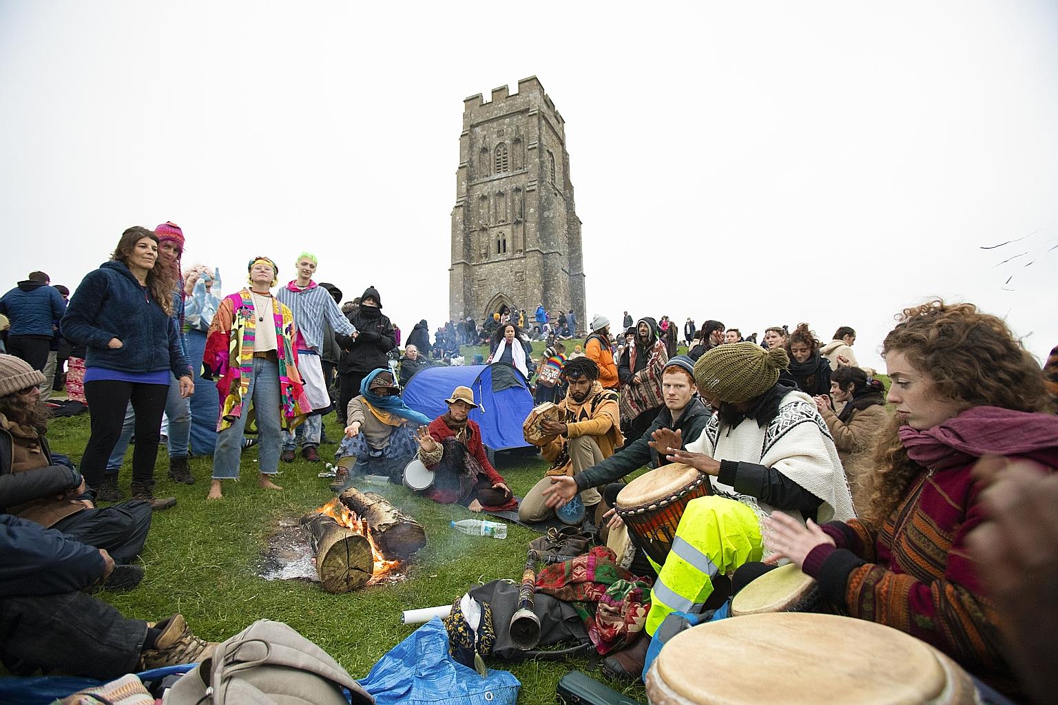 Undeterred by poor weather, hundreds of people gathered at Glastonbury Tor, a hill near the World Heritage site Stonehenge in Somerset, England, yesterday to watch the sun rise and set in celebration of the annual summer solstice. Marking the longest