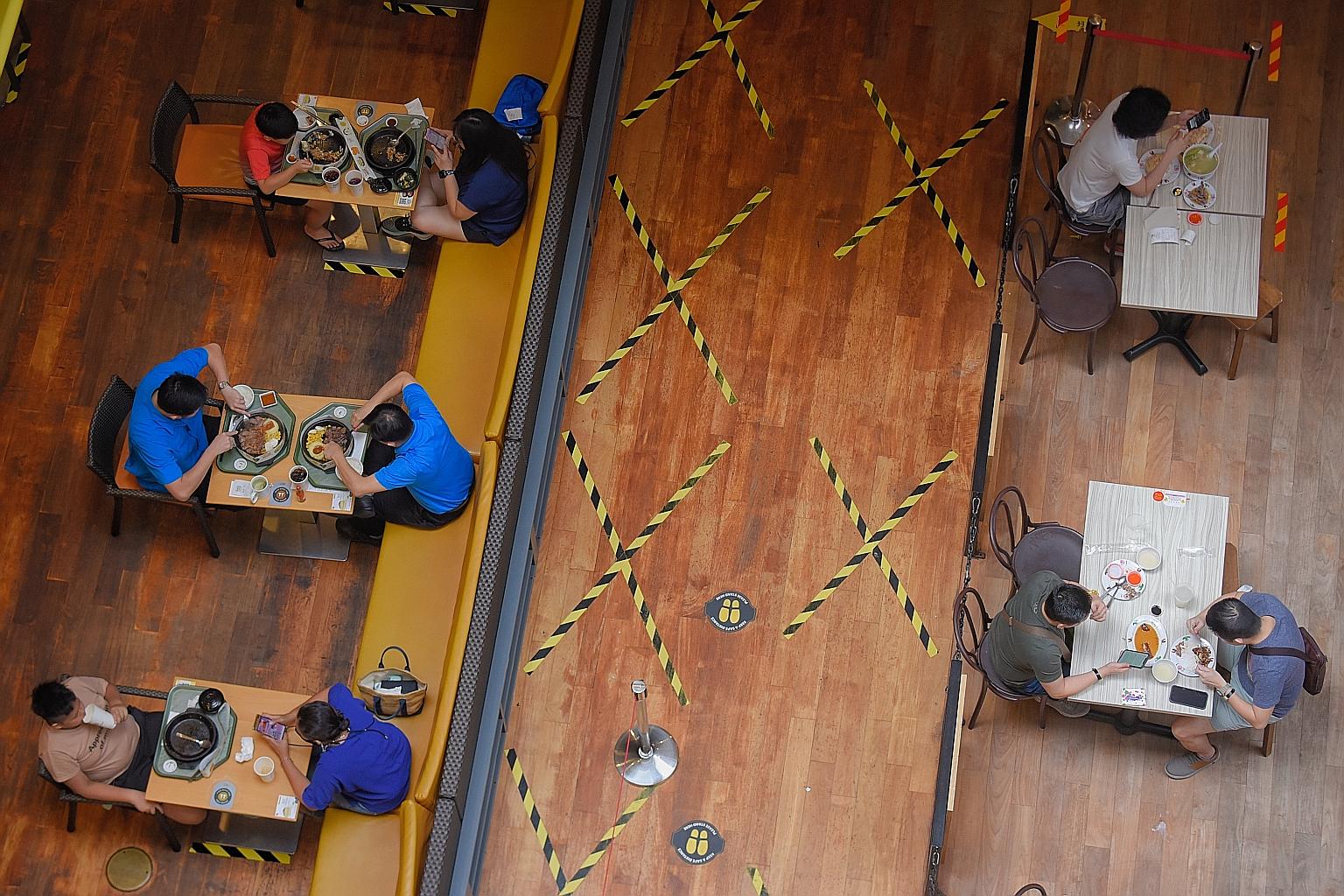 Diners sitting in pairs while having their meal at Jurong Point mall yesterday. Dining in was allowed for the first time yesterday since May 16, though it was restricted to two patrons per table, and diners had to pull up their masks as soon as their