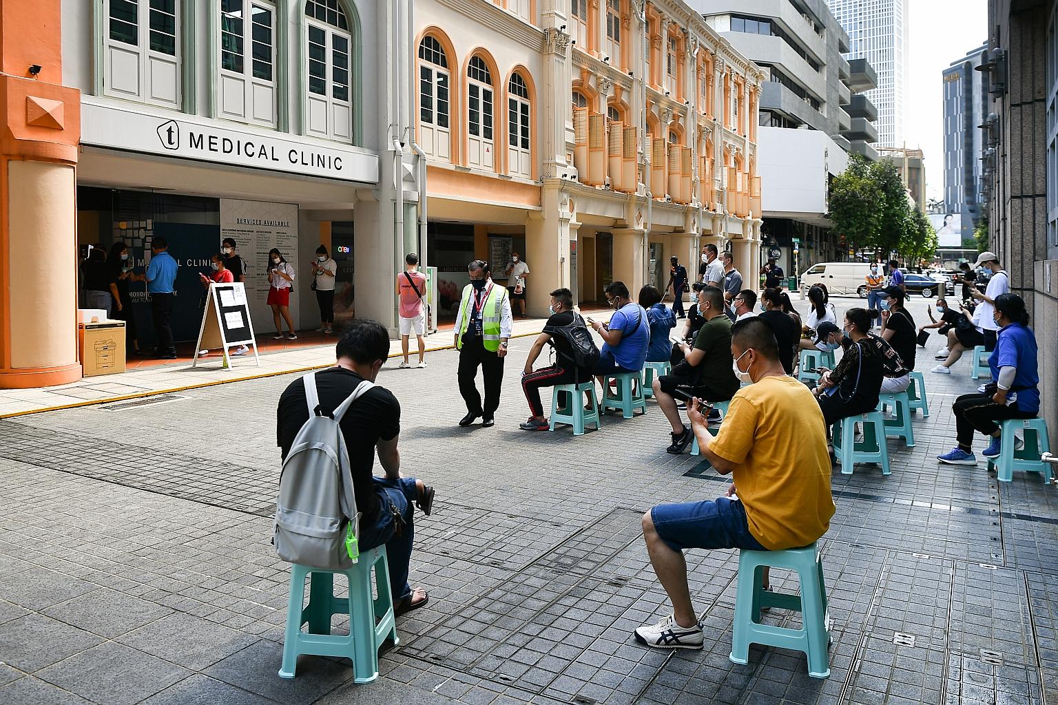 People waiting to take the Sinovac vaccine outside Doctors for Life Medical at 3 Pickering Street yesterday. It is one of 24 private healthcare clinics selected by the authorities as licensed providers of the vaccine, drawing on the Government's exis