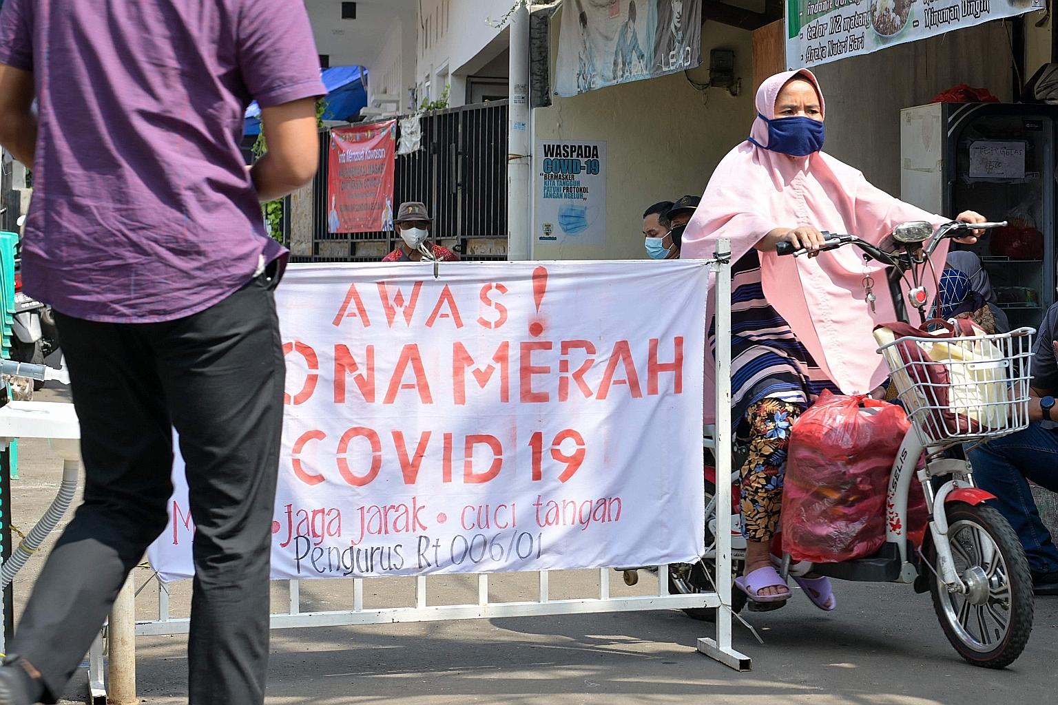 A sign saying "Beware! Covid-19 red zone" at a residential area in Jakarta indicates a neighbourhood that has had Covid-19 cases in at least 10 households in the past seven days. However, some experts in Indonesia believe that the colour-coded system